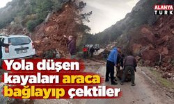 Yola düşen kayaları iple araca bağlayıp çektiler